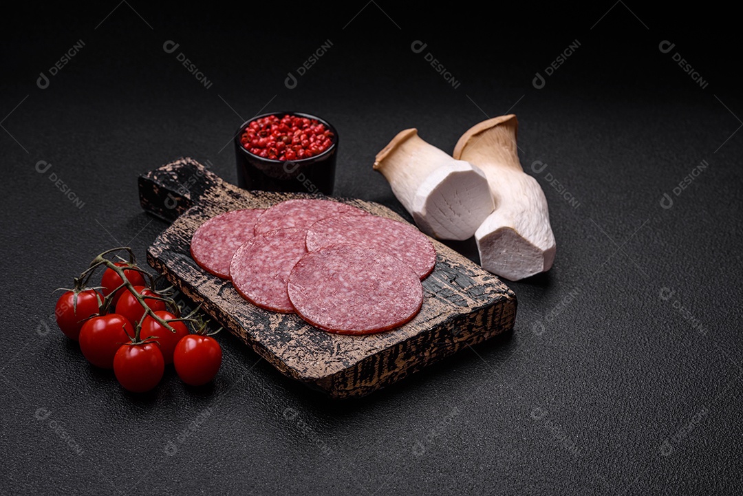 Deliciosa salsicha fresca fumada com sal e especiarias cortadas em fatias sobre um fundo escuro de concreto