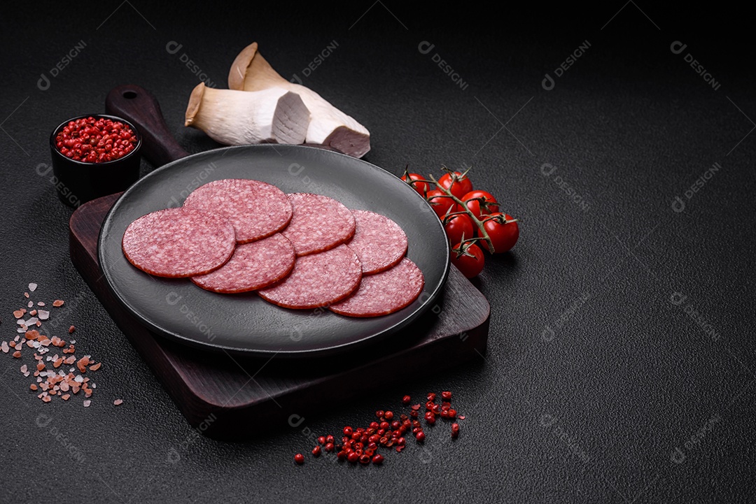 Deliciosa salsicha fresca fumada com sal e especiarias cortadas em fatias sobre um fundo escuro de concreto