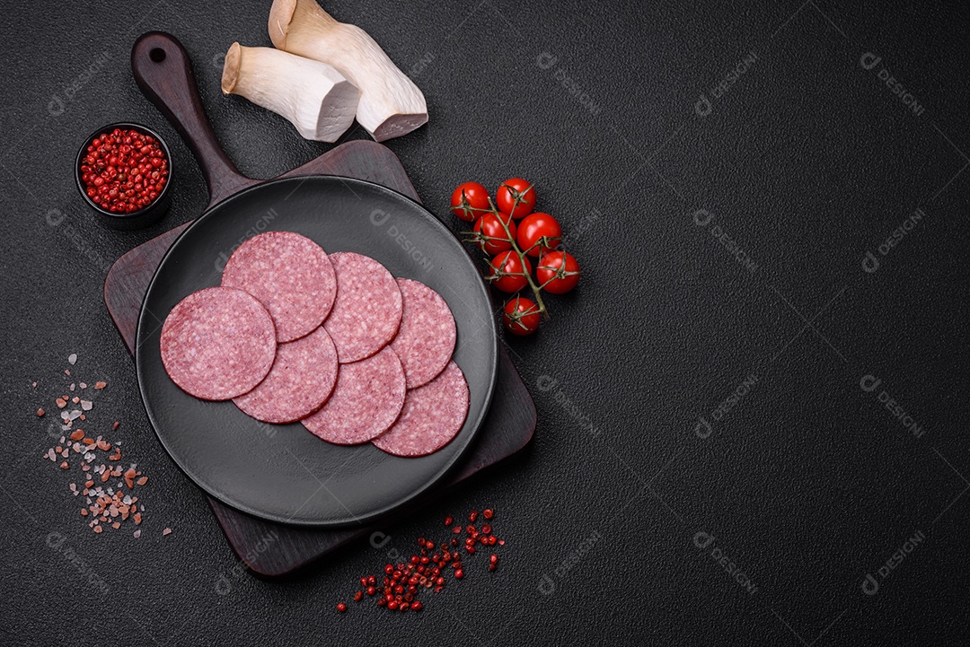 Deliciosa salsicha fresca fumada com sal e especiarias cortadas em fatias sobre um fundo escuro de concreto