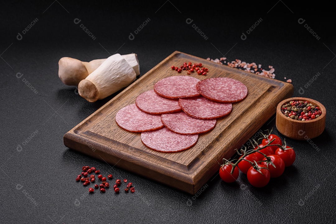 Deliciosa salsicha fresca fumada com sal e especiarias cortadas em fatias sobre um fundo escuro de concreto