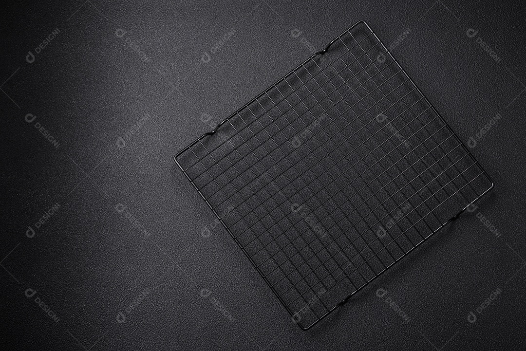Grelha vazia de cozinha de metal preto para derramar sobremesas em fundo escuro de concreto