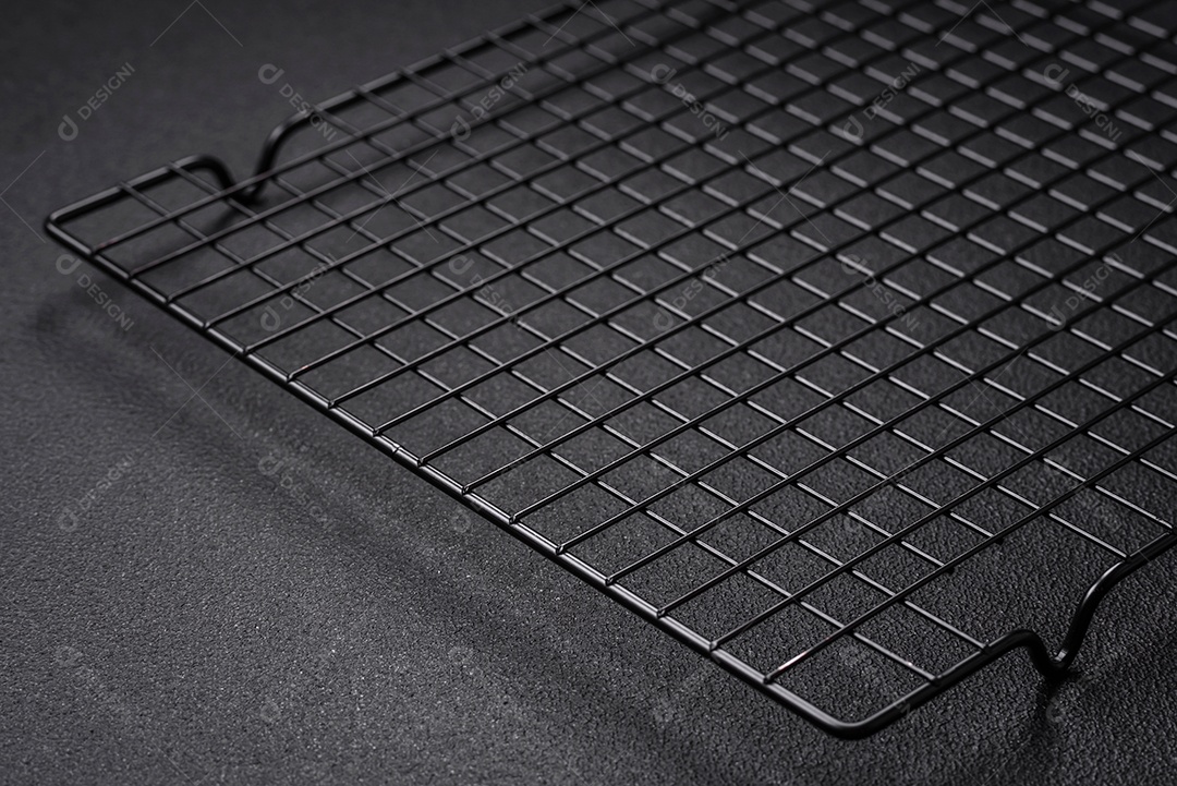 Grelha vazia de cozinha de metal preto para derramar sobremesas em fundo escuro de concreto
