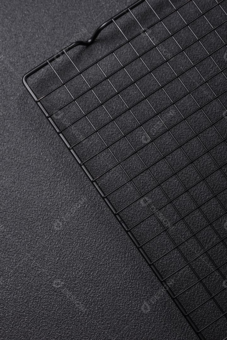 Grelha vazia de cozinha de metal preto para derramar sobremesas em fundo escuro de concreto