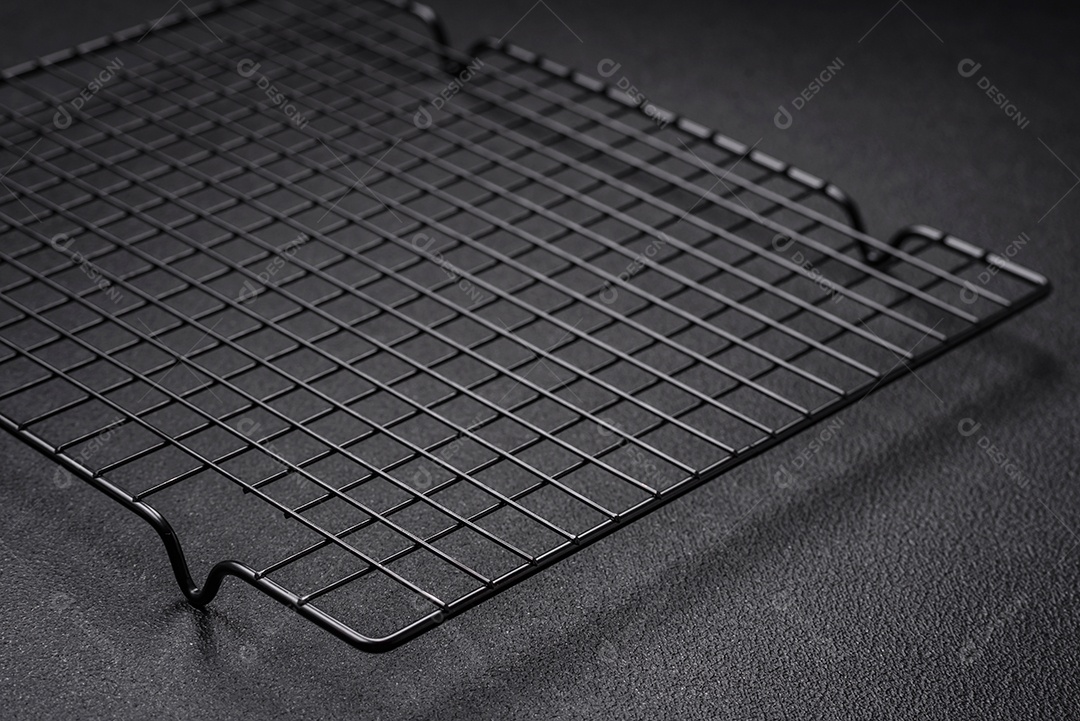 Grelha vazia de cozinha de metal preto para derramar sobremesas em fundo escuro de concreto
