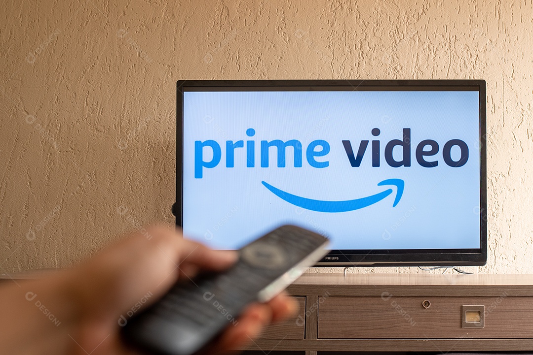 Mão com controle ligando tv na prime videos para assistir