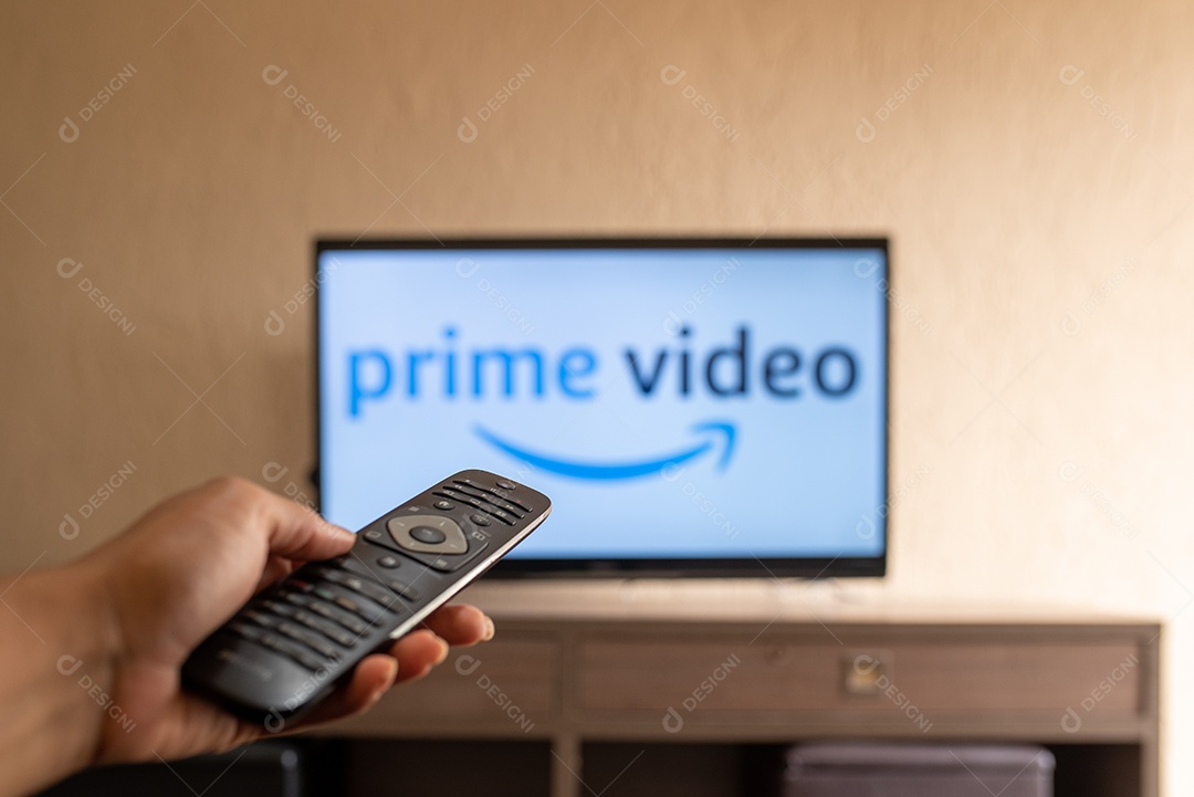 Mão com controle ligando tv na prime videos para assistir