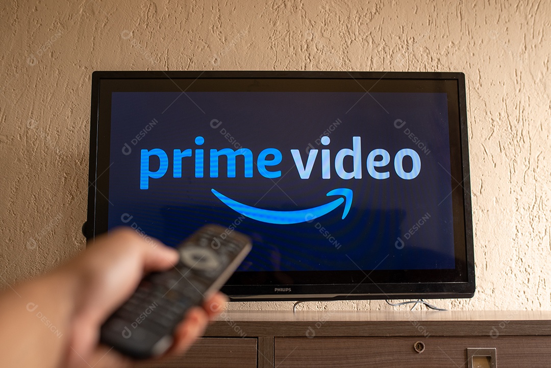 Mão com controle ligando tv na prime videos para assistir