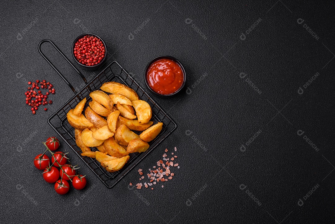 Deliciosas fatias de batata frita crocante com sal, especiarias e ervas sobre um fundo escuro de concreto