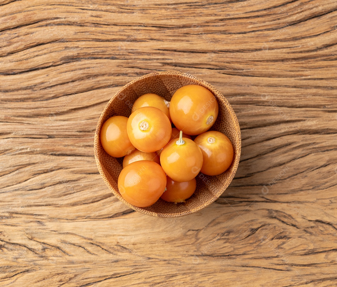 Physalis em uma tigela sobre uma mesa de madeira.