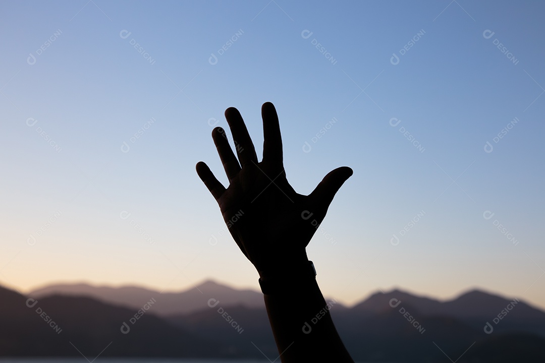 Silhueta de mãos em forma de número cinco com um lindo céu colorido de fim de tarde