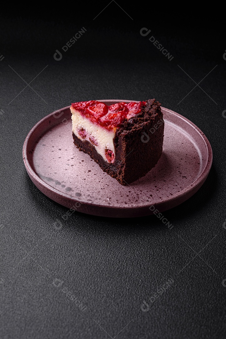 Linda e saborosa fatia doce de cheesecake com cereja em uma placa de cerâmica sobre um fundo escuro de concreto