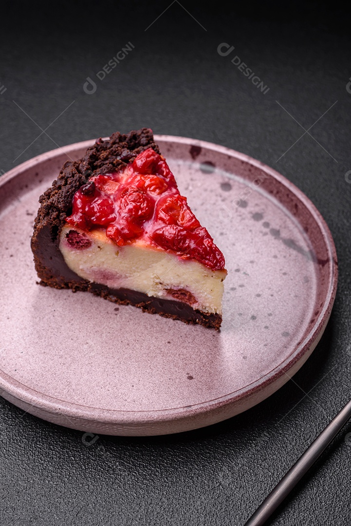 Linda e saborosa fatia doce de cheesecake com cereja em uma placa de cerâmica sobre um fundo escuro de concreto