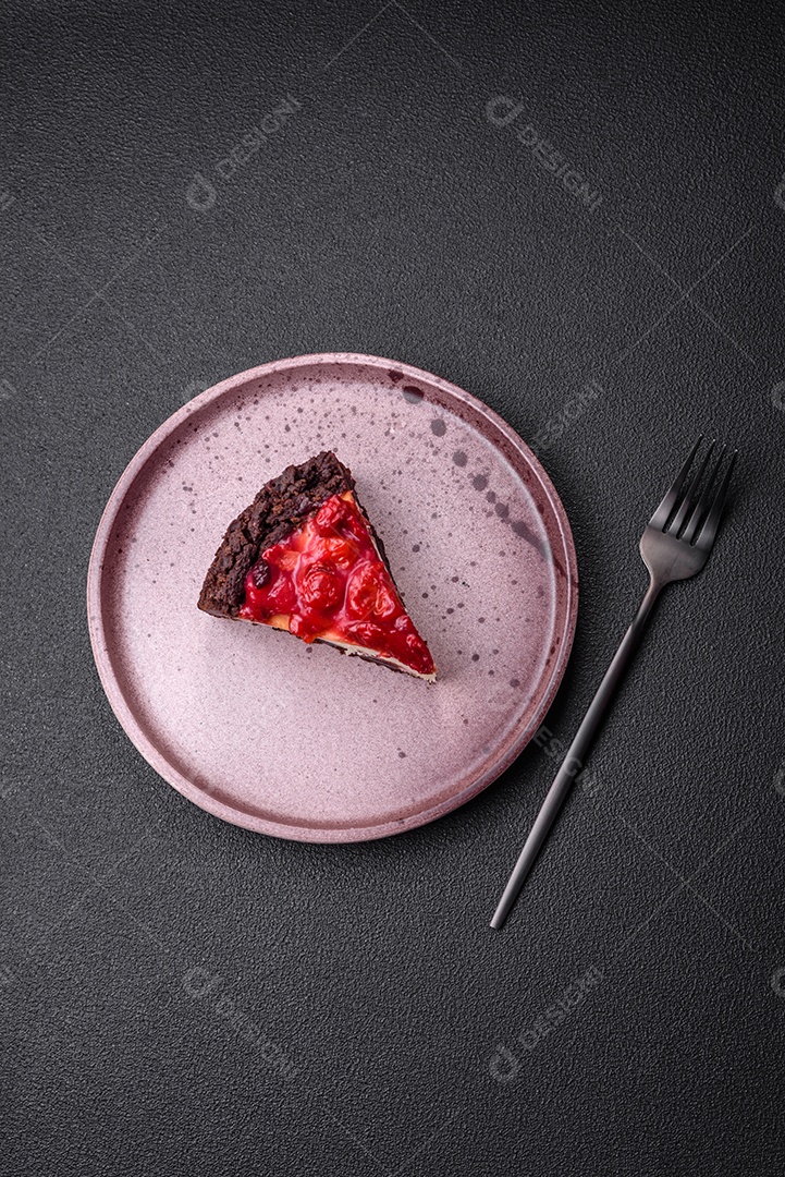 Linda e saborosa fatia doce de cheesecake com cereja em uma placa de cerâmica sobre um fundo escuro de concreto