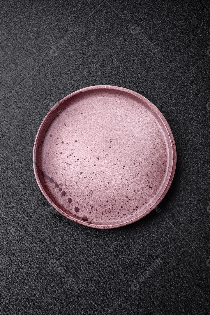 Prato cerâmico vazio em um fundo escuro texturizado. Preparando utensílios de cozinha para um jantar em família