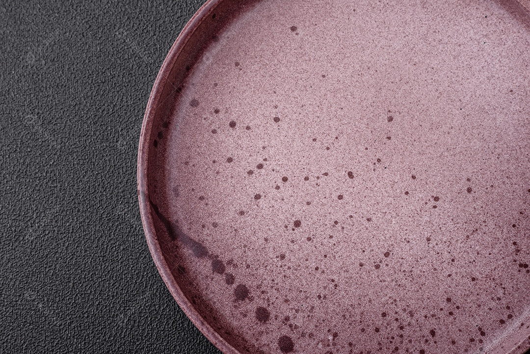 Prato cerâmico vazio em um fundo escuro texturizado. Preparando utensílios de cozinha para um jantar em família