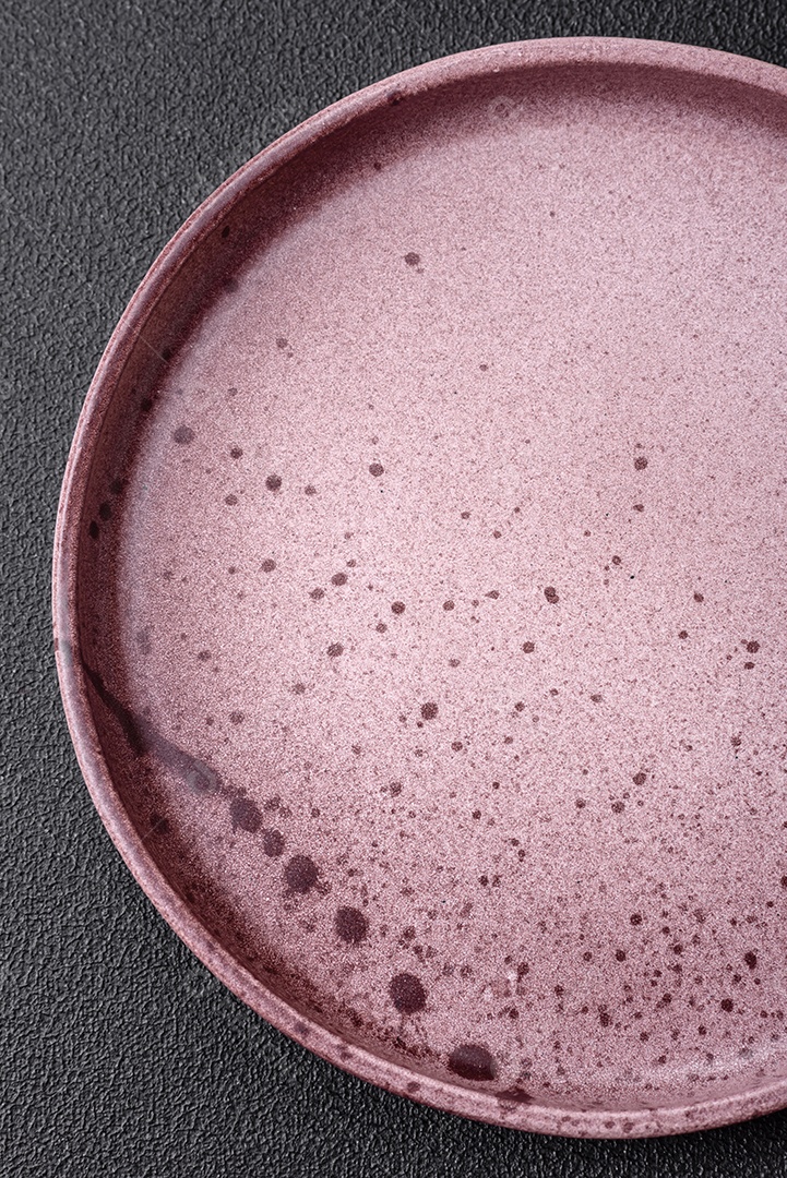 Prato cerâmico vazio em um fundo escuro texturizado. Preparando utensílios de cozinha para um jantar em família