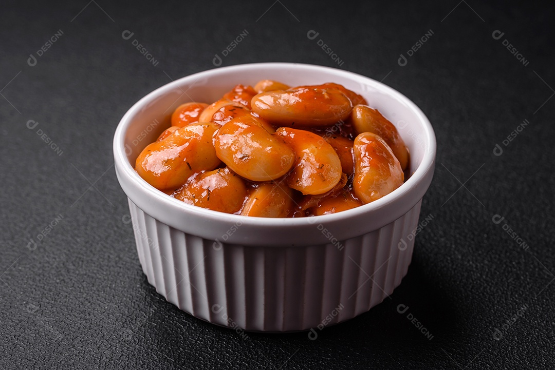 Deliciosos feijões enlatados em um tomate em uma tigela de cerâmica branca