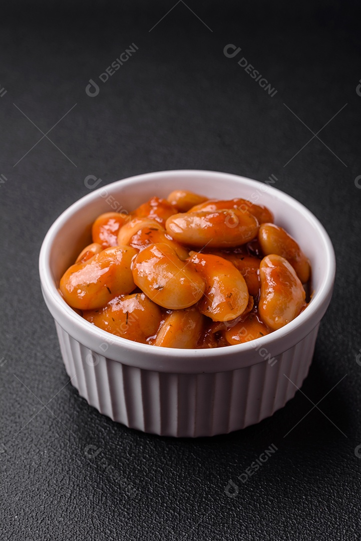 Deliciosos feijões enlatados em um tomate em uma tigela de cerâmica branca