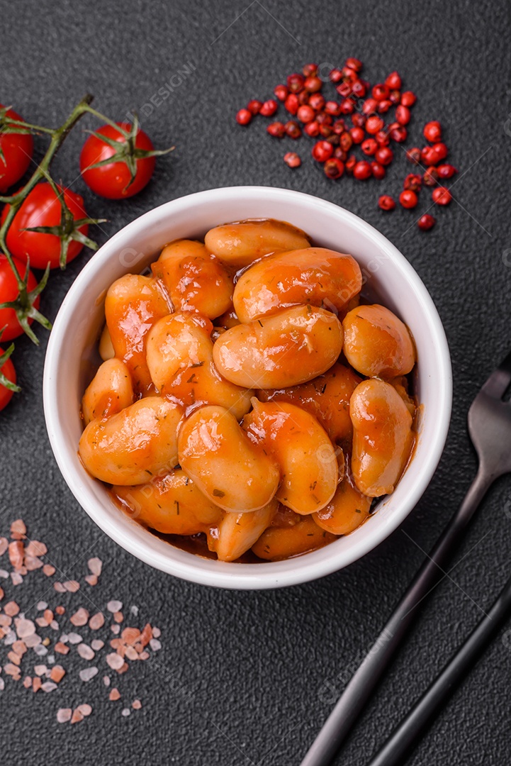 Deliciosos feijões enlatados em um tomate em uma tigela de cerâmica branca