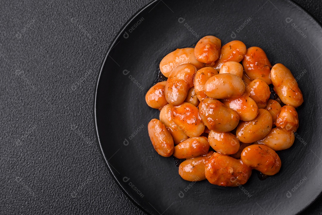 Deliciosos feijões enlatados em um tomate em uma tigela de cerâmica branca
