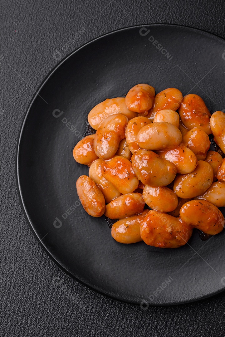 Deliciosos feijões enlatados em um tomate em uma tigela de cerâmica branca
