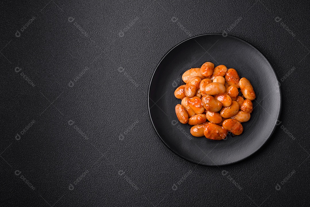 Deliciosos feijões enlatados em um tomate em uma tigela de cerâmica branca