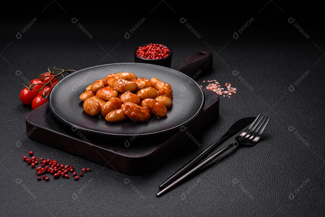 Deliciosos feijões enlatados em um tomate em uma tigela de cerâmica branca