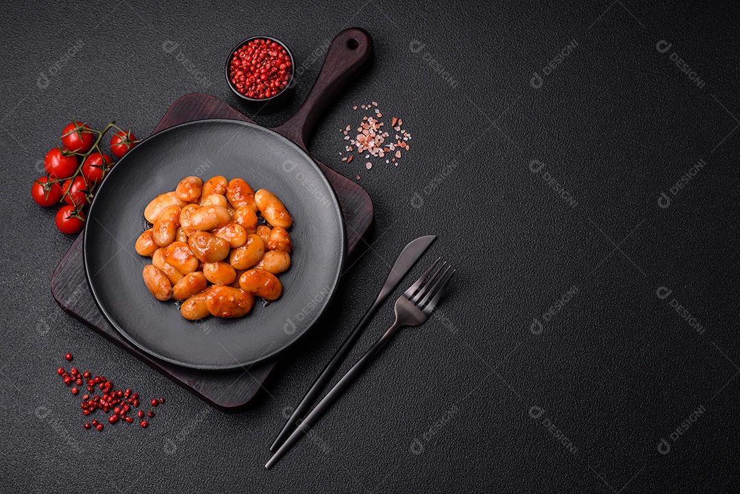 Deliciosos feijões enlatados em um tomate em uma tigela de cerâmica branca