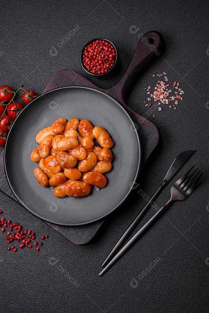 Deliciosos feijões enlatados em um tomate em uma tigela de cerâmica branca