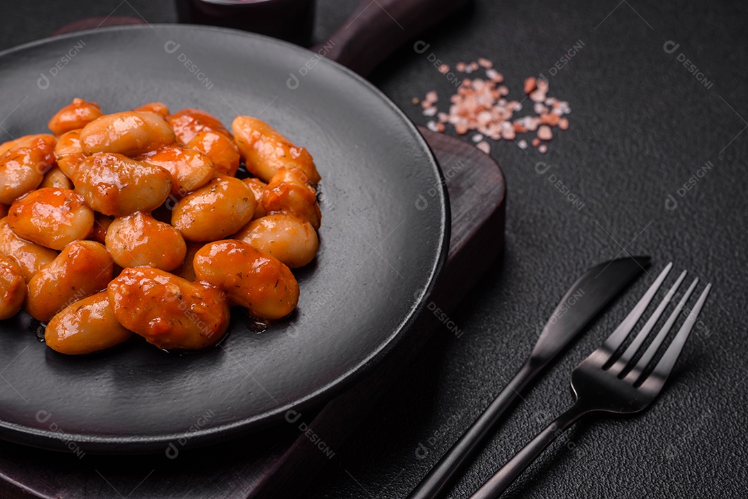 Deliciosos feijões enlatados em um tomate em uma tigela de cerâmica branca