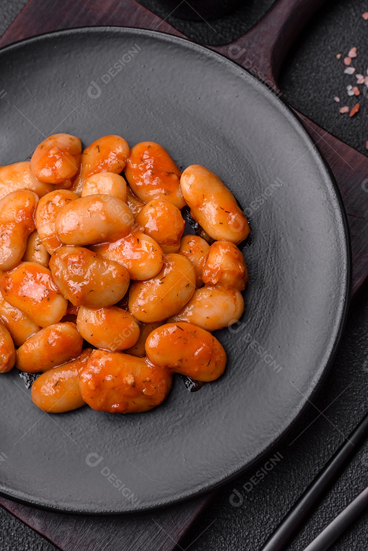 Deliciosos feijões enlatados em um tomate em uma tigela de cerâmica branca