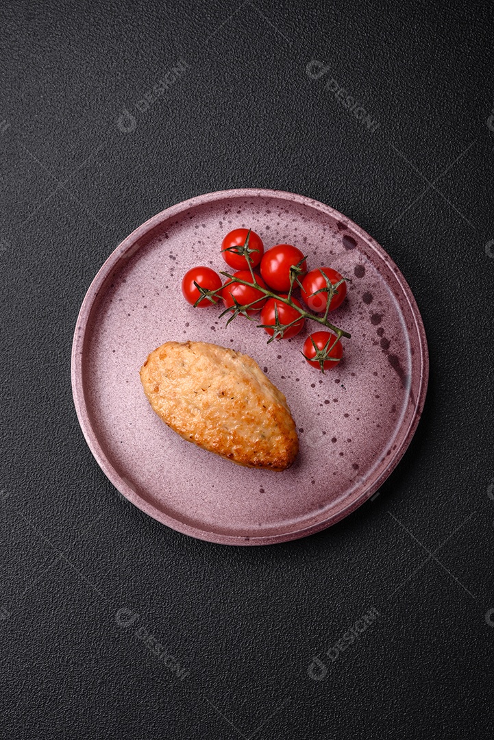 Deliciosas costeletas de frango fresco ou almôndegas com sal, especiarias e ervas sobre um fundo escuro de concreto