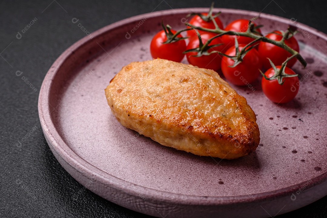 Deliciosas costeletas de frango fresco ou almôndegas com sal, especiarias e ervas sobre um fundo escuro de concreto