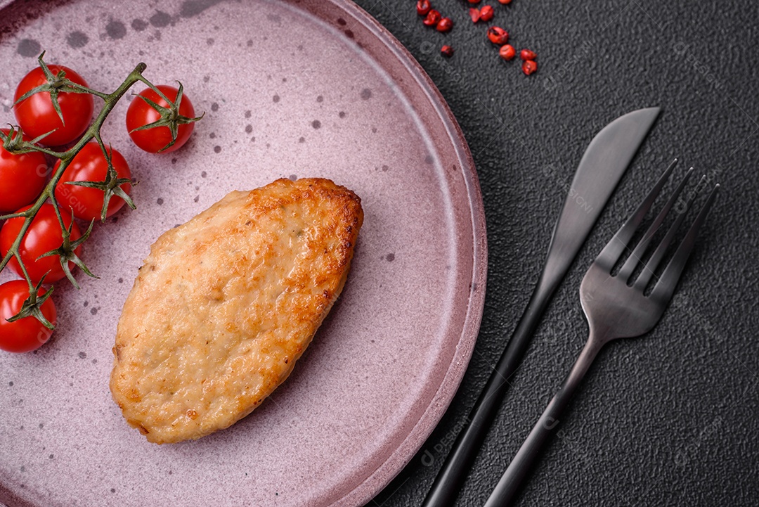 Deliciosa costeleta de soja vegetariana frita fresca com sal, especiarias e ervas com legumes em uma placa de cerâmica sobre um fundo escuro de concreto