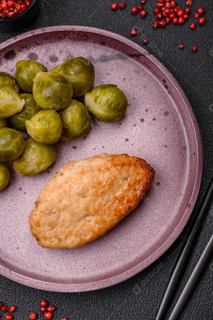 Deliciosas couves de Bruxelas cozidas em um prato de cerâmica sobre um fundo escuro de concreto. Comida vegetariana