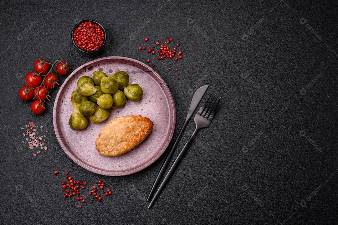 Deliciosas couves de Bruxelas cozidas em um prato de cerâmica sobre um fundo escuro de concreto. Comida vegetariana