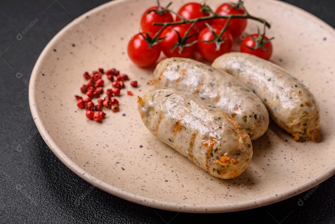 Deliciosos enchidos de frango ou porco grelhados com sal, especiarias e ervas sobre um fundo escuro de concreto