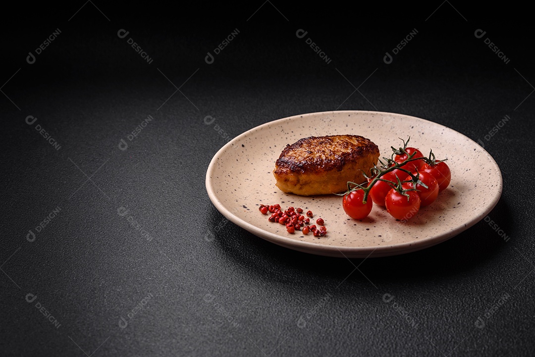 Deliciosa costeleta de soja vegetariana frita fresca com sal, especiarias e ervas com legumes em uma placa de cerâmica sobre um fundo escuro de concreto