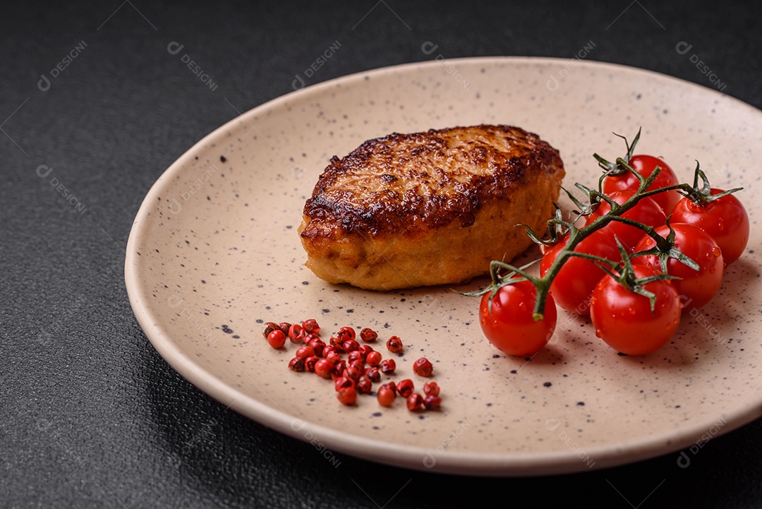 Deliciosa costeleta de soja vegetariana frita fresca com sal, especiarias e ervas com legumes em uma placa de cerâmica sobre um fundo escuro de concreto