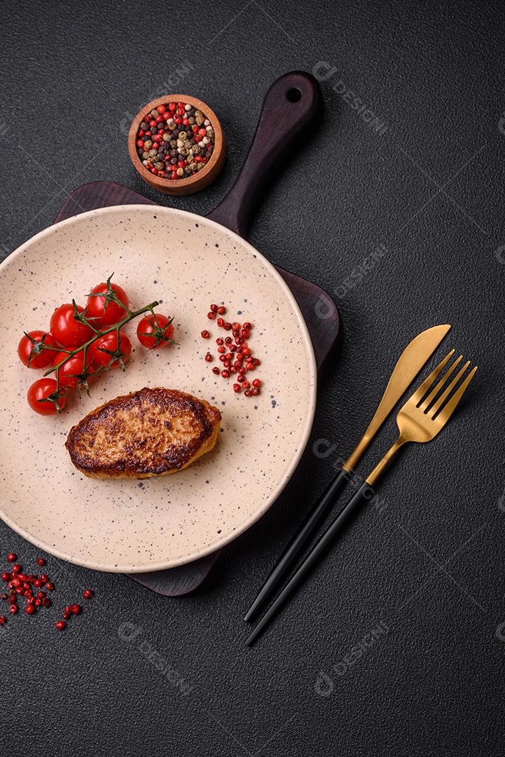 Deliciosa costeleta de soja vegetariana frita fresca com sal, especiarias e ervas com legumes em uma placa de cerâmica sobre um fundo escuro de concreto