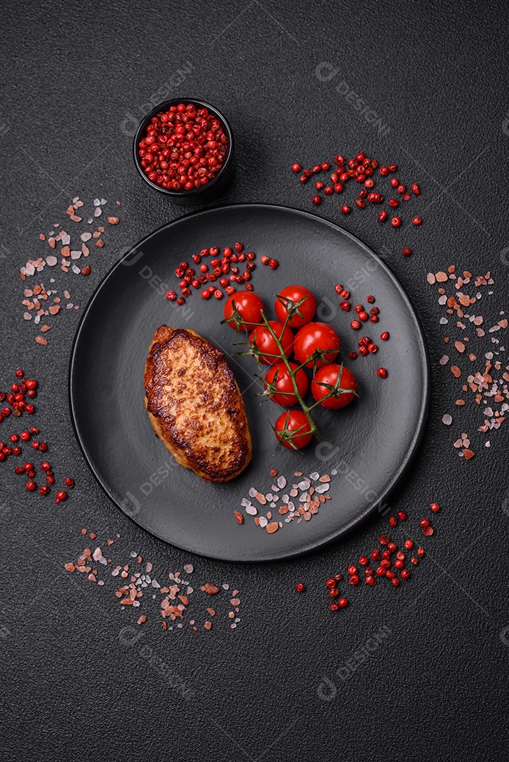 Deliciosas costeletas de frango fresco ou almôndegas com sal, especiarias e ervas sobre um fundo escuro de concreto