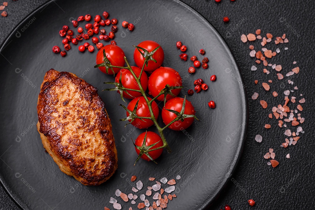 Deliciosas costeletas de frango fresco ou almôndegas com sal, especiarias e ervas sobre um fundo escuro de concreto