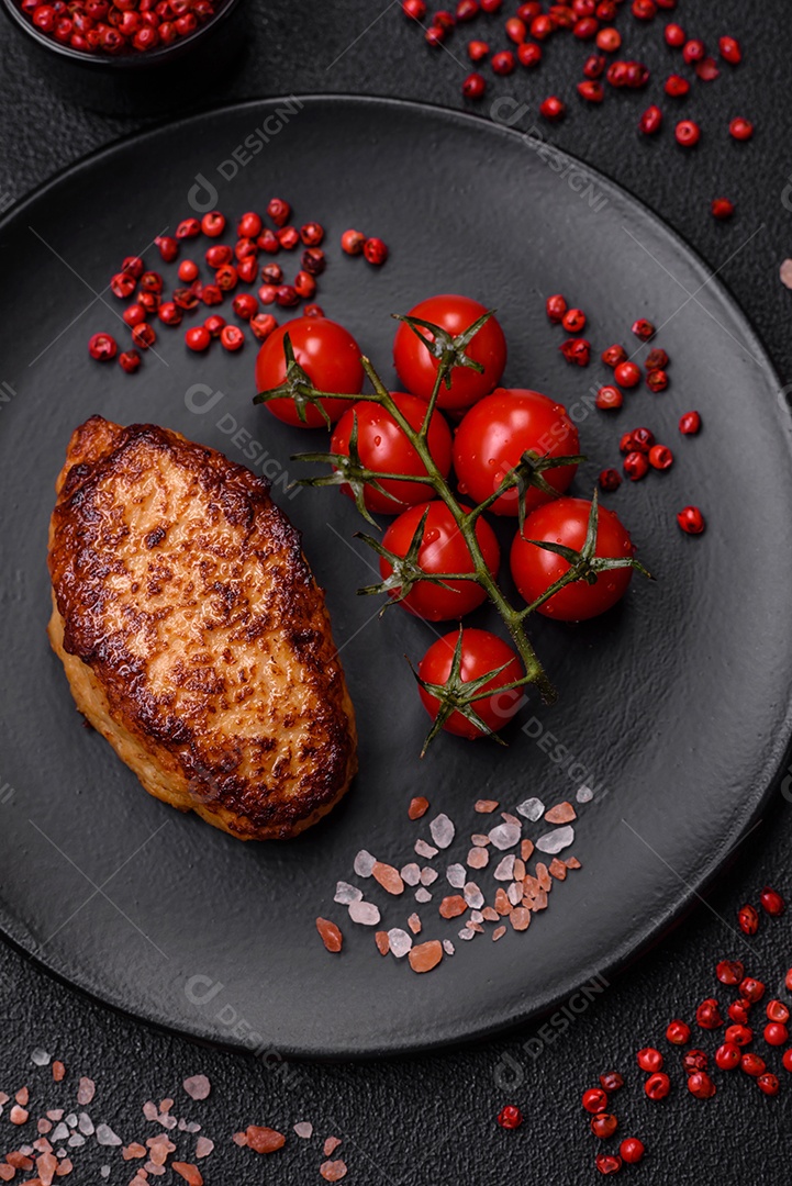 Deliciosa costeleta de soja vegetariana frita fresca com sal, especiarias e ervas com legumes em uma placa de cerâmica sobre um fundo escuro de concreto