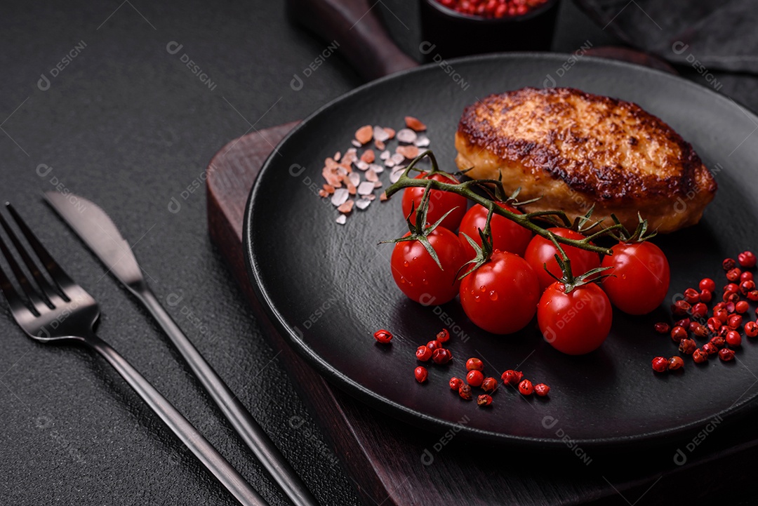 Deliciosa costeleta de soja vegetariana frita fresca com sal, especiarias e ervas com legumes em uma placa de cerâmica sobre um fundo escuro de concreto