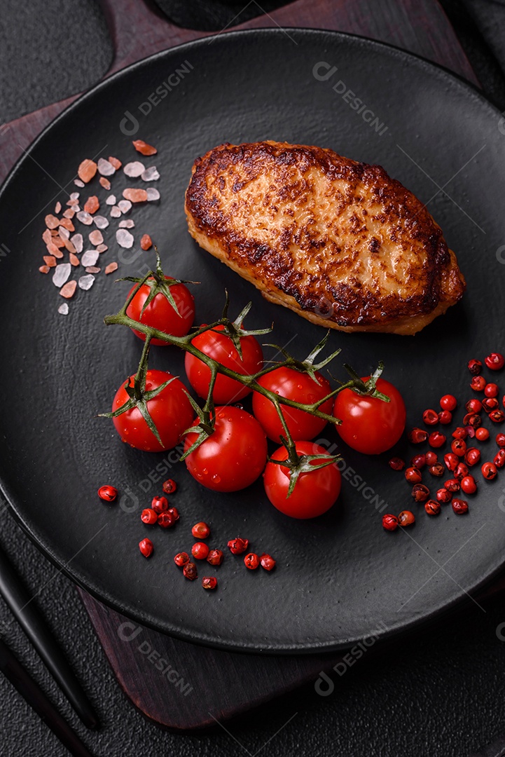 Deliciosa costeleta de soja vegetariana frita fresca com sal, especiarias e ervas com legumes em uma placa de cerâmica sobre um fundo escuro de concreto