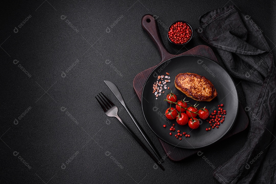 Deliciosas costeletas de frango fresco ou almôndegas com sal, especiarias e ervas sobre um fundo escuro de concreto