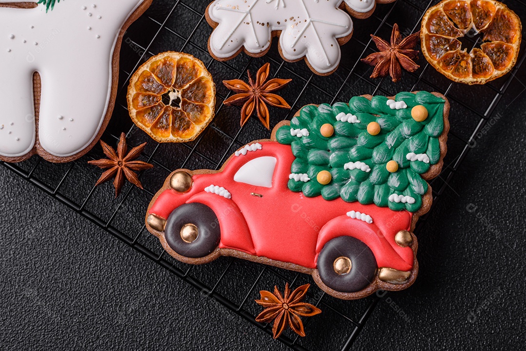 Biscoitos de gengibre frescos e deliciosos de Natal ou ano novo com padrão temático de cor brilhante em fundo escuro de concreto