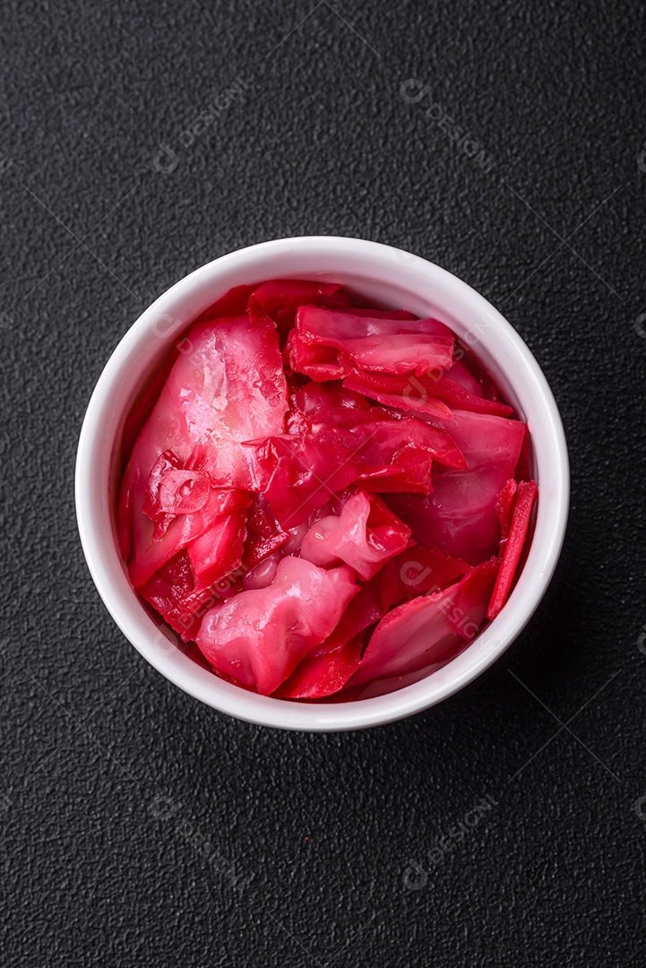 Delicioso repolho rosa picante cortado e cozido em estilo coreano em uma placa cerâmica sobre um fundo escuro de concreto