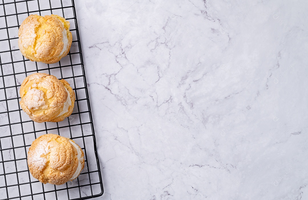 Creme choux, chantilly de baunilha recheado bolo sobre grade de metal com espaço de cópia.