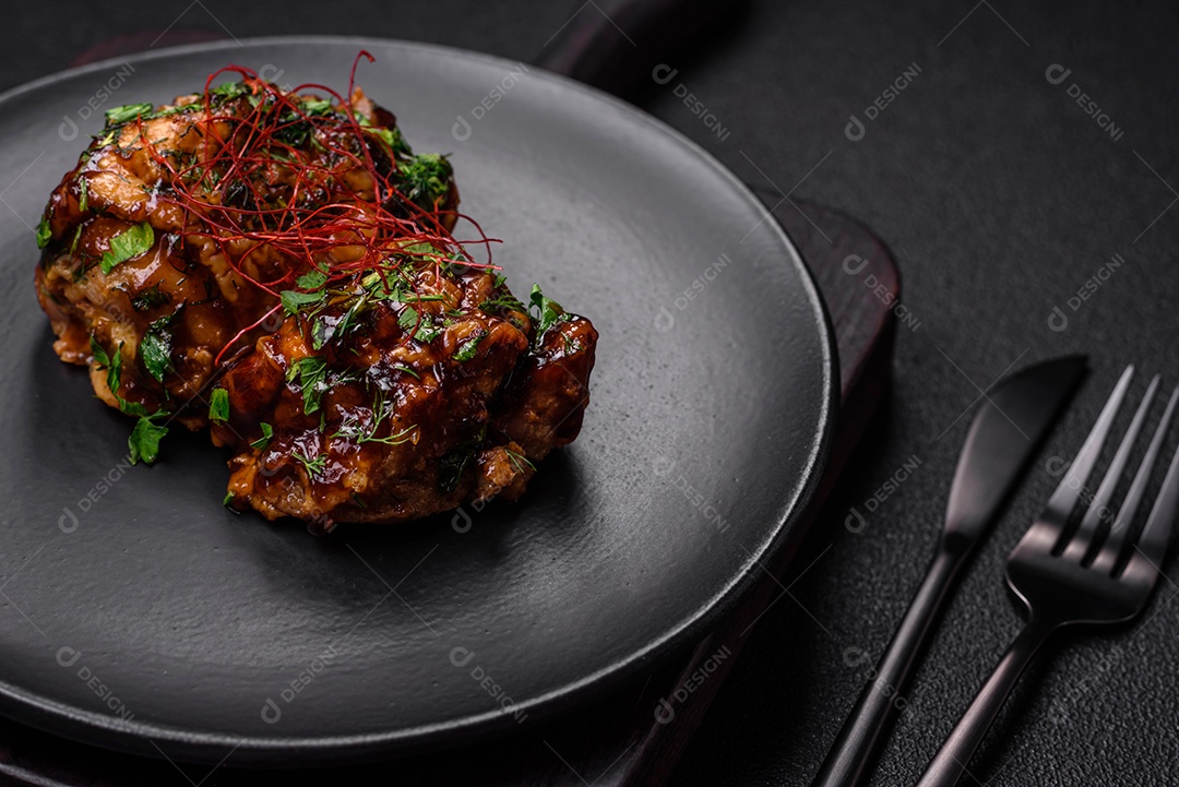 Delicioso frango frito suculento em molho teriyaki com sal, especiarias, ervas e sementes de gergelim num prato cerâmic